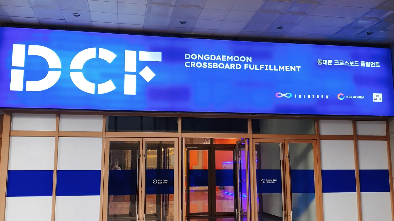 DCF 센터 정문. 파란 사인에 DCF Dongdaemoon Crossboard Fulfillment 로고가 켜져 있다.